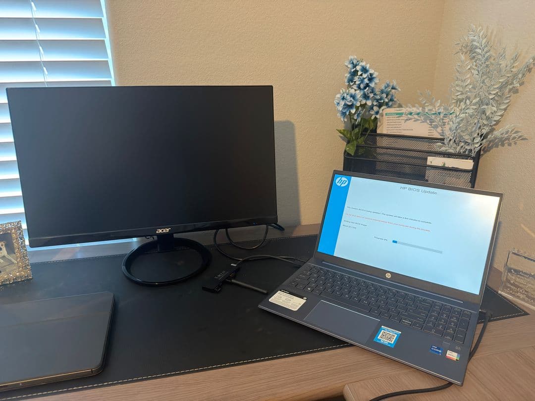 An HP laptop running a BIOS update on Matt's desk, next to a monitor