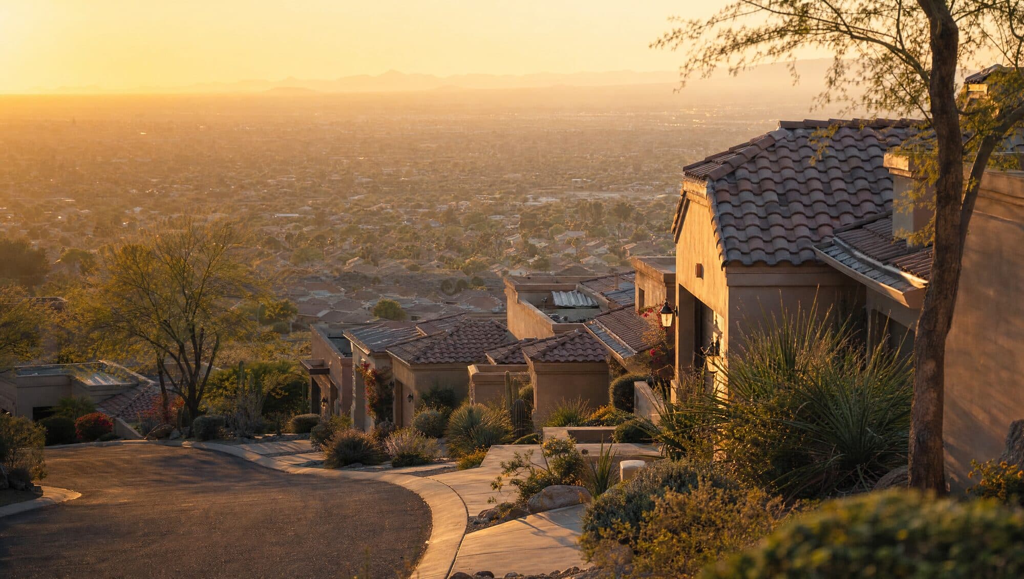 Tile-roof homes on a hillside at golden hour with a valley below