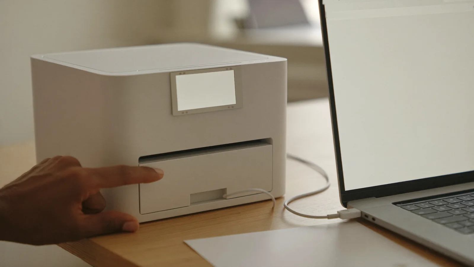Printer and laptop being set up together on a small office desk